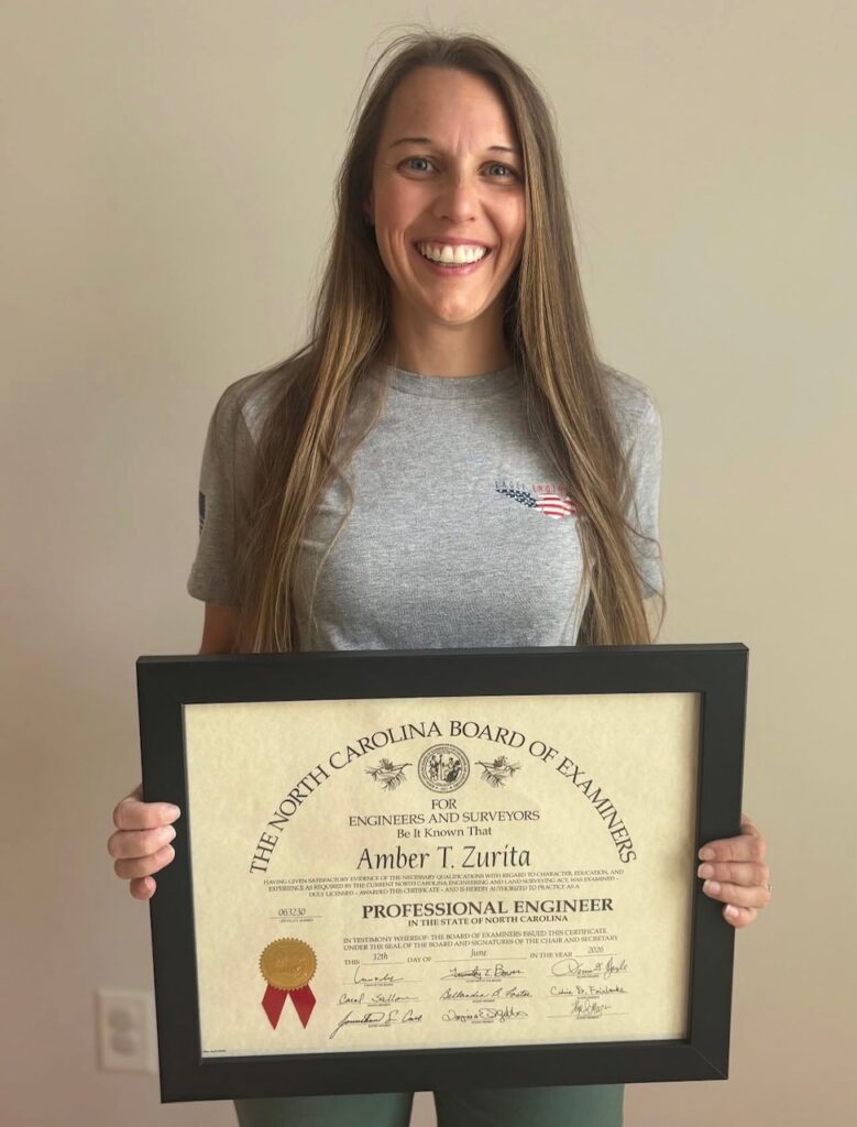 Eagle Engineering team member smiling and holding a professional certificate